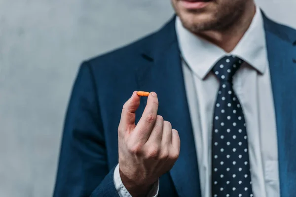 Tiro cortado de viciado empresário segurando pílula de drogas — Fotografia de Stock