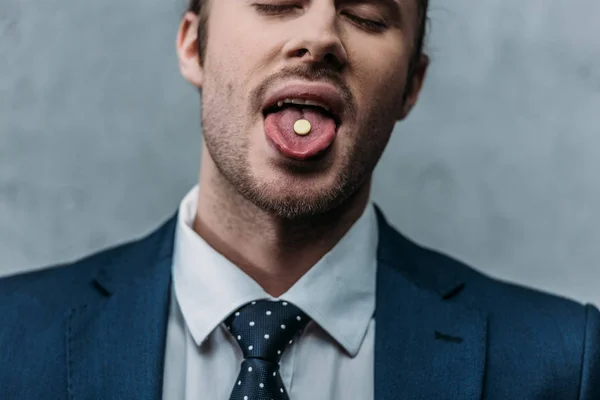 Retrato de cerca del hombre de negocios adicto que sobresale de la lengua con la píldora mdma - foto de stock