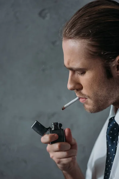 Primer plano retrato del hombre fumando cigarrillo en frente de la pared de hormigón - foto de stock