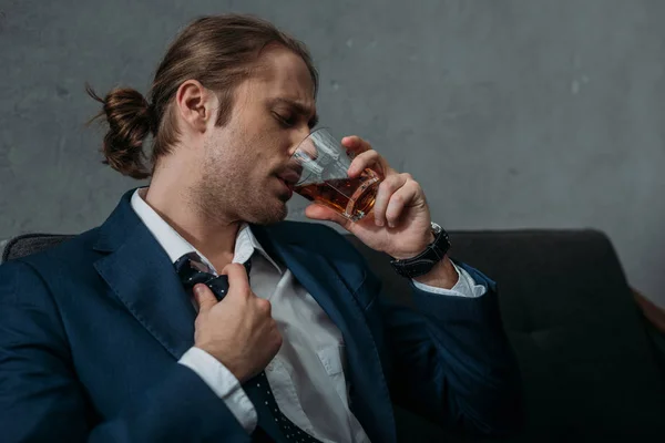 Young alcohol addicted businessman drinking whiskey — Stock Photo