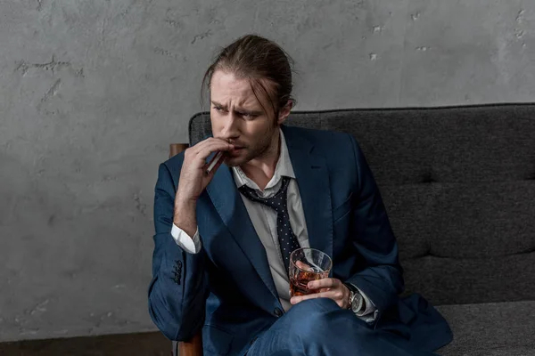 Drunk alcohol addicted businessman with glass of whiskey smoking cigarette — Stock Photo