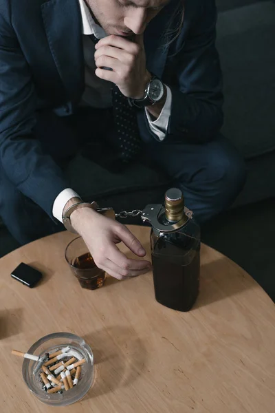 Homme d'affaires accro à l'alcool avec verre et bouteille de whisky — Photo de stock