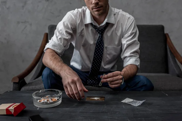 Cropped shot of young businessman with drug addiction preparing to take cocaine — Stock Photo