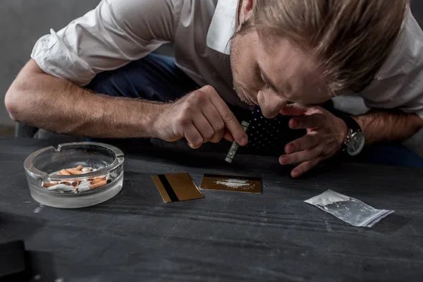 Close-up shot of businessman with drug addiction sniffing cocaine — Stock Photo