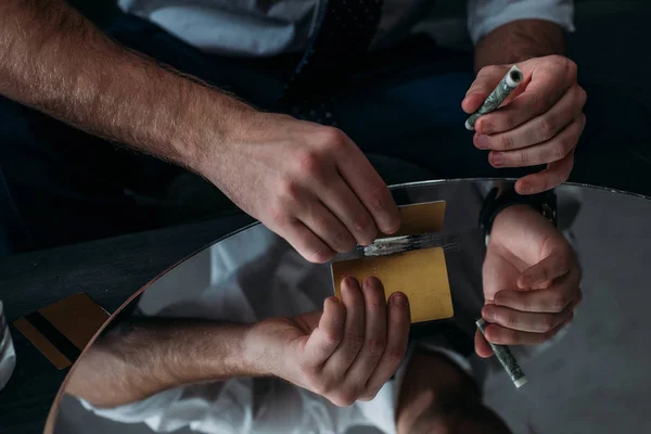 Cropped shot of businessman with drug addiction sniffing cocaine from mirror — Stock Photo