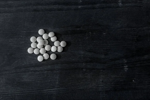 Top view of mdma pills on black wooden surface — Stock Photo