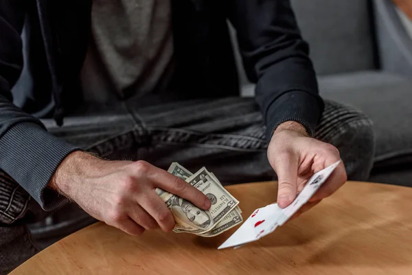 Recortado tiro de con efectivo y cartas hombre jugando al póquer - foto de stock