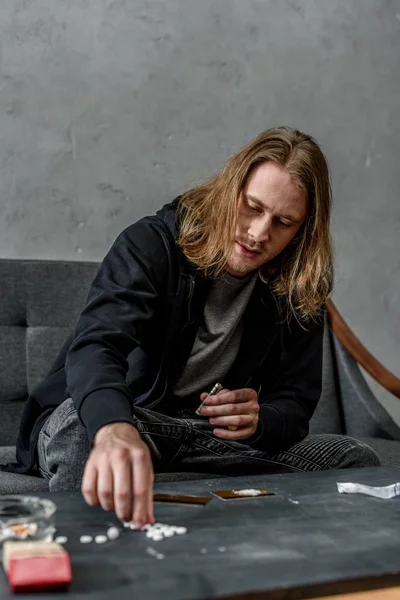 Addicted junkie taking mdma pill from table — Stock Photo