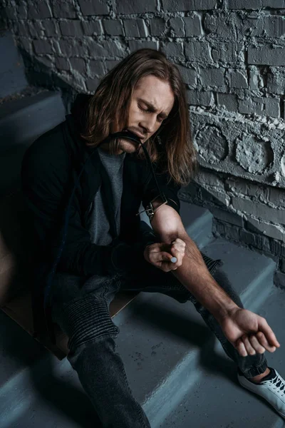 Addicted junkie doing heroin injection on stairs — Stock Photo