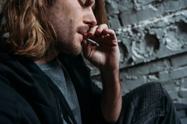 Close-up shot of young man smoking cigarette — Stock Photo