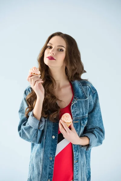 Menina atraente feliz segurando cupcakes isolados em cinza — Fotografia de Stock