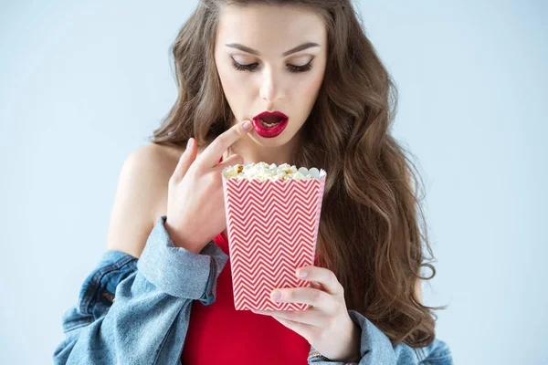 Surprised sexy girl looking at popcorn isolated on grey — Stock Photo