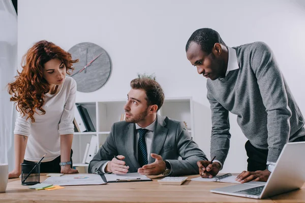 Multiethnic coworkers doing paperwork in office — Stock Photo