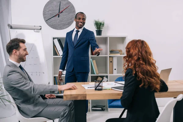 Conseiller financier montrant la présentation aux clients dans un bureau moderne — Photo de stock