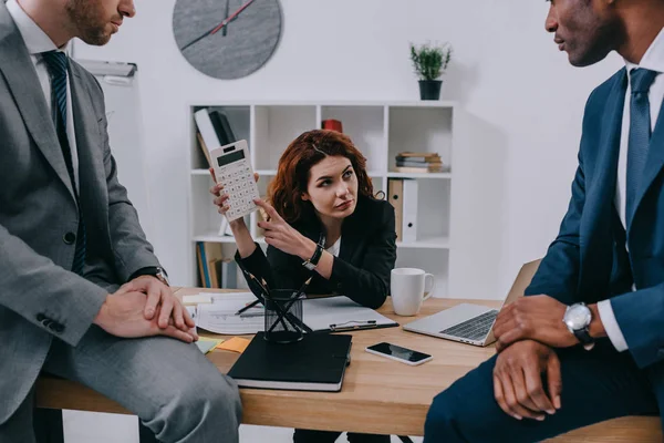 Investment adviser showing calculation to businessmen — Stock Photo