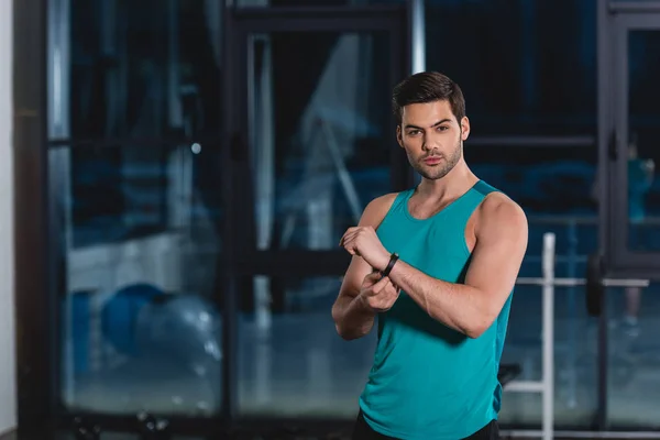 Handsome sporty man with fitness tracker in gym — Stock Photo
