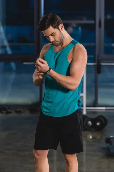 Deportista con rastreador de fitness en pabellón deportivo - foto de stock