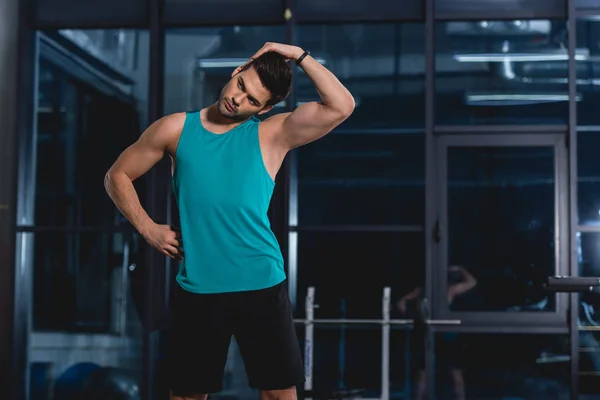 Sportsman stretching neck in sports hall — Stock Photo