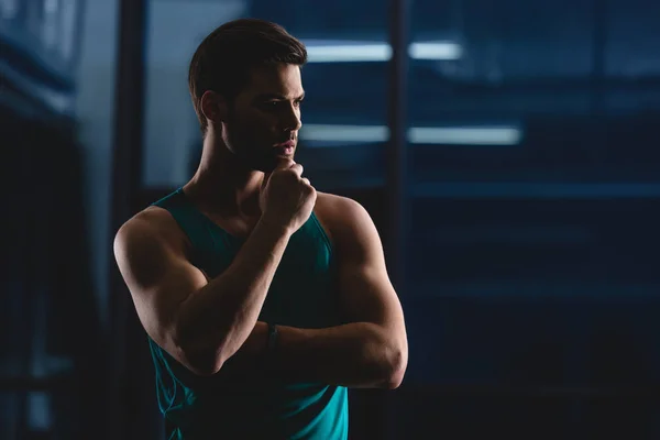 Silhouette of thoughtful muscular sportsman in gym — Stock Photo