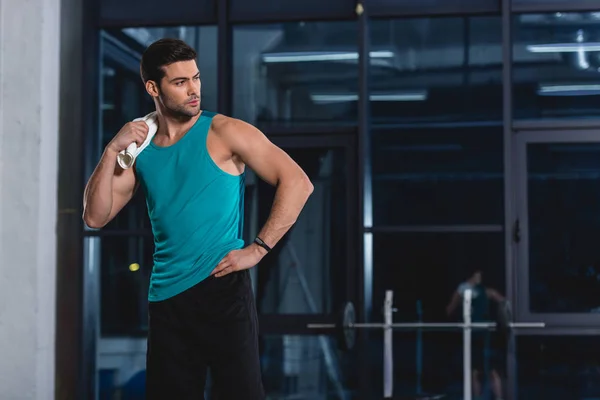 Deportista de pie con toalla después del entrenamiento en el gimnasio - foto de stock