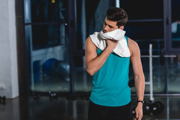 Tired sweaty sportsman with towel after training in gym — Stock Photo