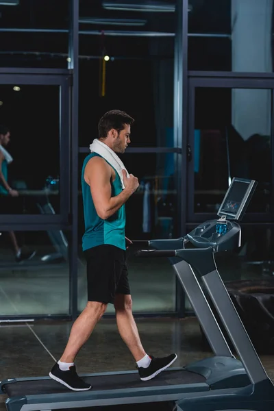 Sportif fatigué avec serviette d'entraînement sur tapis roulant dans la salle de gym — Photo de stock