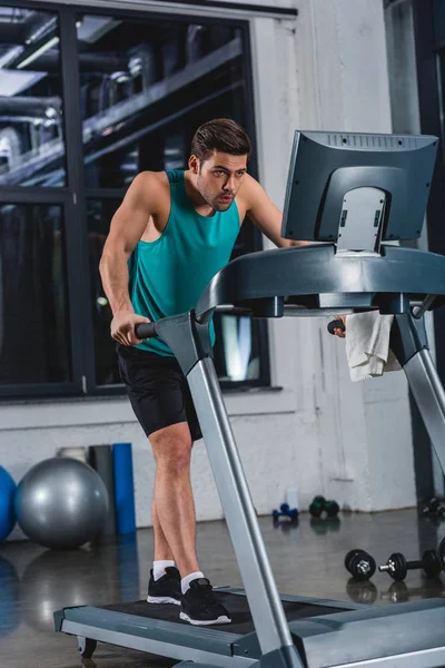 Tired sportsman training on treadmill in gym — Stock Photo