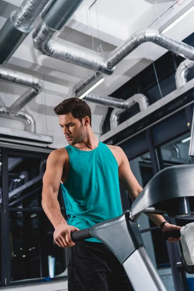 Handsome sportsman exercising on treadmill in gym — Stock Photo