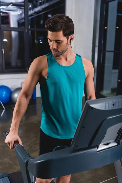 Sportsman training on treadmill in sports hall — Stock Photo