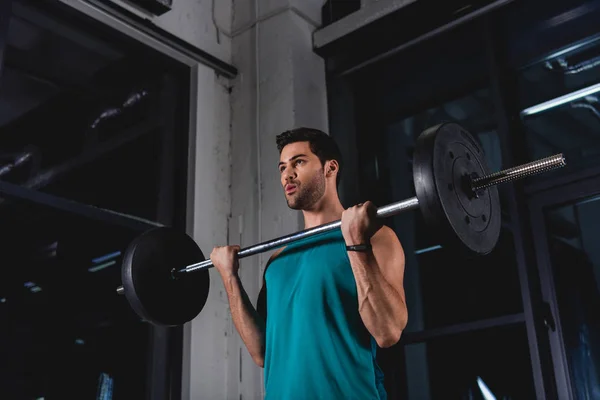 Sportsman lifting barbell during cross training in gym — Stock Photo