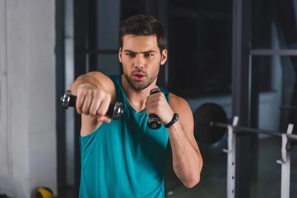 Deportista muscular haciendo ejercicio con pesas en el gimnasio — Stock Photo