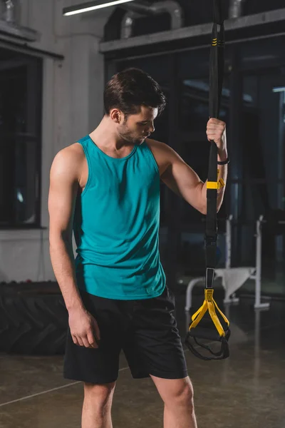 Desportista de pé com tiras de suspensão no ginásio — Fotografia de Stock