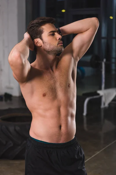 Shirtless muscular sportsman posing in sports hall — Stock Photo