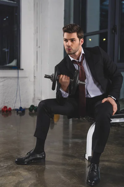 Entrenador deportivo en traje de entrenamiento con mancuerna en el gimnasio - foto de stock