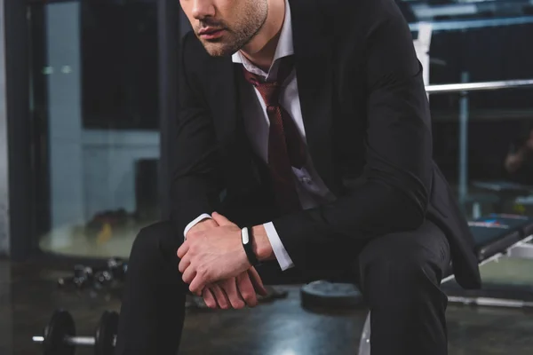 Ausgeschnittene Ansicht eines müden Geschäftsmannes im Anzug mit Fitness-Tracker im Fitnessstudio — Stockfoto