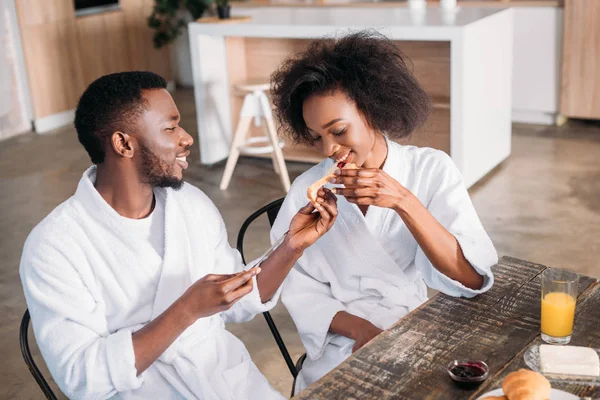 Joven alimentación novia en la mesa en la cocina - foto de stock