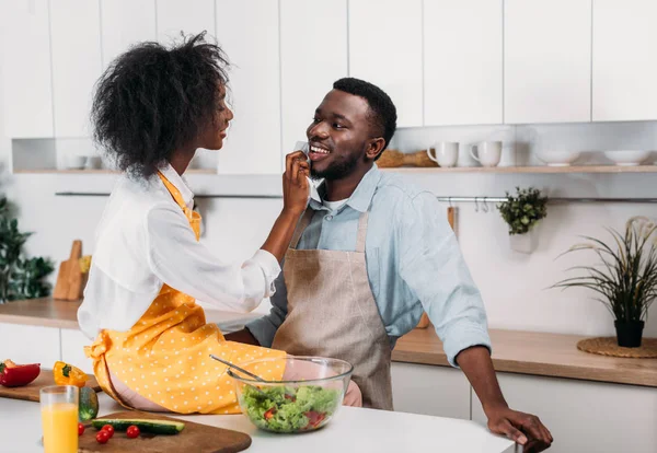 Jovem afro-americana limpando boca de namorado por guardanapo — Fotografia de Stock