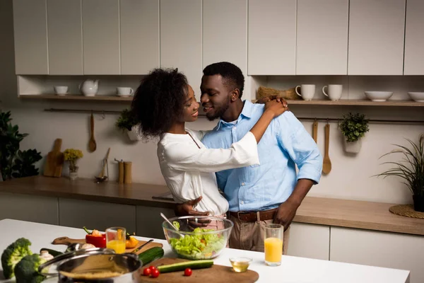 Junge afrikanisch-amerikanische Pärchen umarmen sich in der Küche — Stockfoto