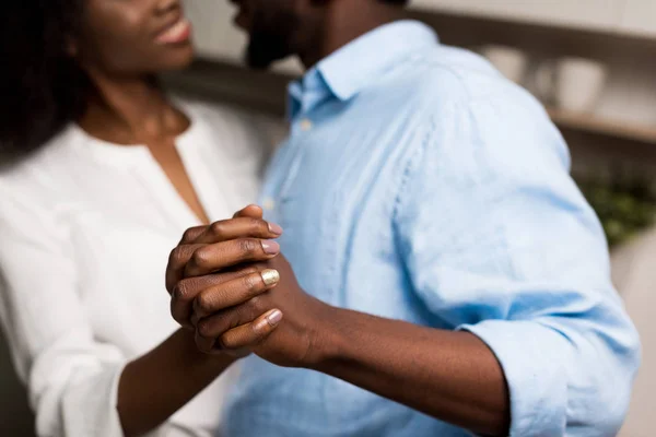 Abgeschnittenes Bild eines lächelnden afrikanisch-amerikanischen Paares, das sich die Hände hält — Stockfoto