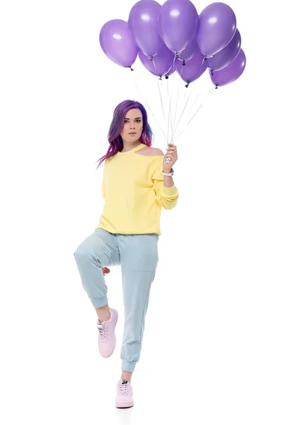 Stylish young woman holding bunch of helium balloons — Stock Photo