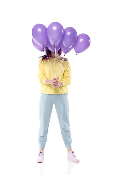 Élégant jeune femme couvrant visage avec bouquet de ballons d'hélium isolé sur blanc — Photo de stock