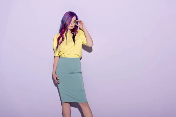 Belle jeune femme aux cheveux colorés et aux lunettes élégantes sur rose — Photo de stock