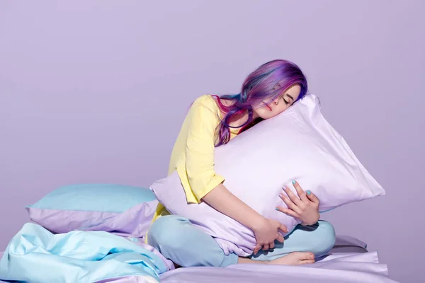 Sleepy young woman sitting in bed and embracing pillow — Stock Photo