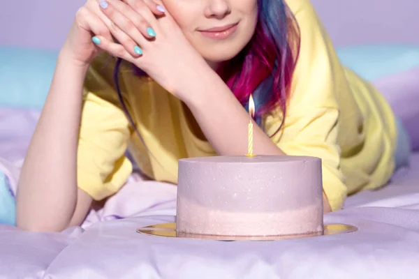 Cropped shot of beautiful woman with birthday cake in bed — Stock Photo