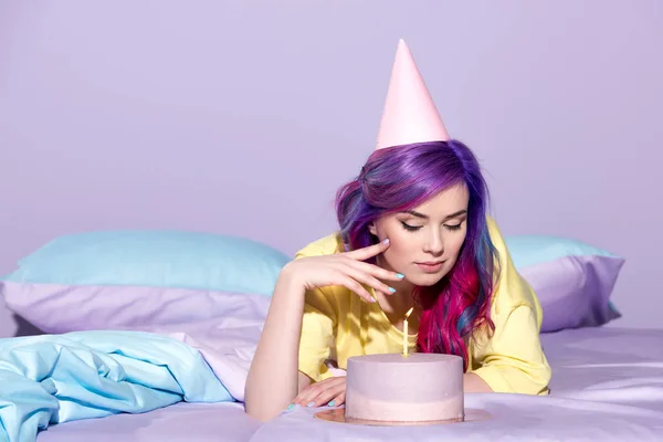 Beautiful young woman with birthday cake in bed — Stock Photo