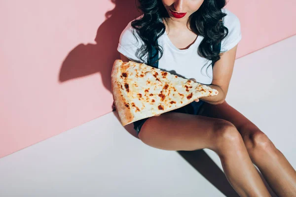 Plan recadré de femme élégante avec morceau de pizza sur fond rose — Photo de stock