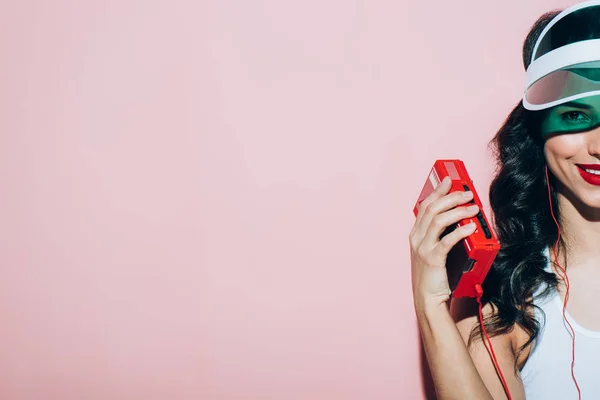 Teilansicht einer lächelnden Frau mit Retro-Musikplayer auf rosa Hintergrund — Stockfoto