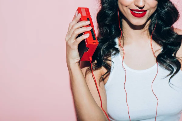 Teilansicht einer lächelnden Frau mit Retro-Musikplayer auf rosa Hintergrund — Stockfoto