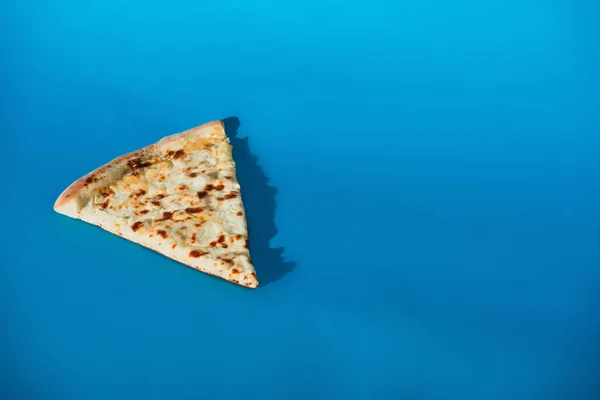 Vista de cerca de pedazo de pizza italiana aislado en azul - foto de stock