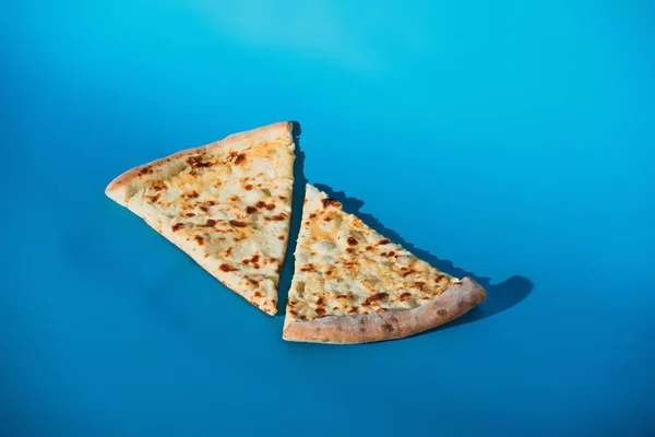 Close up view of pieces of cooked pizza isolated on blue — Stock Photo